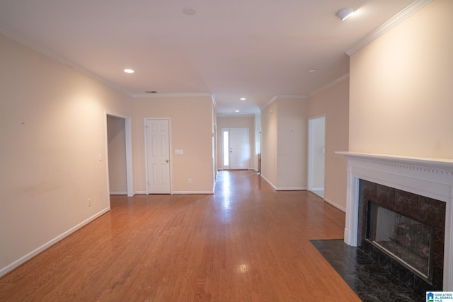 unfurnished living room featuring hardwood / wood-style flooring, ornamental molding, and a tile fireplace