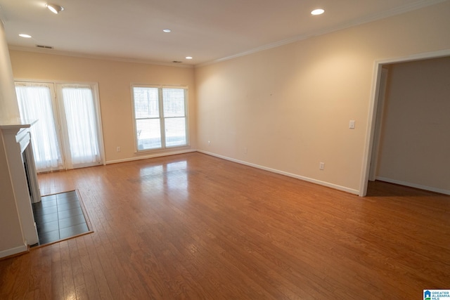 unfurnished living room featuring light wood-type flooring and ornamental molding