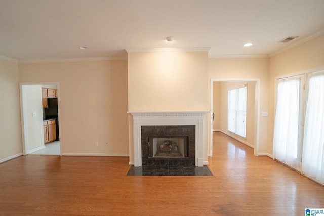 unfurnished living room featuring a fireplace, light wood-type flooring, and crown molding