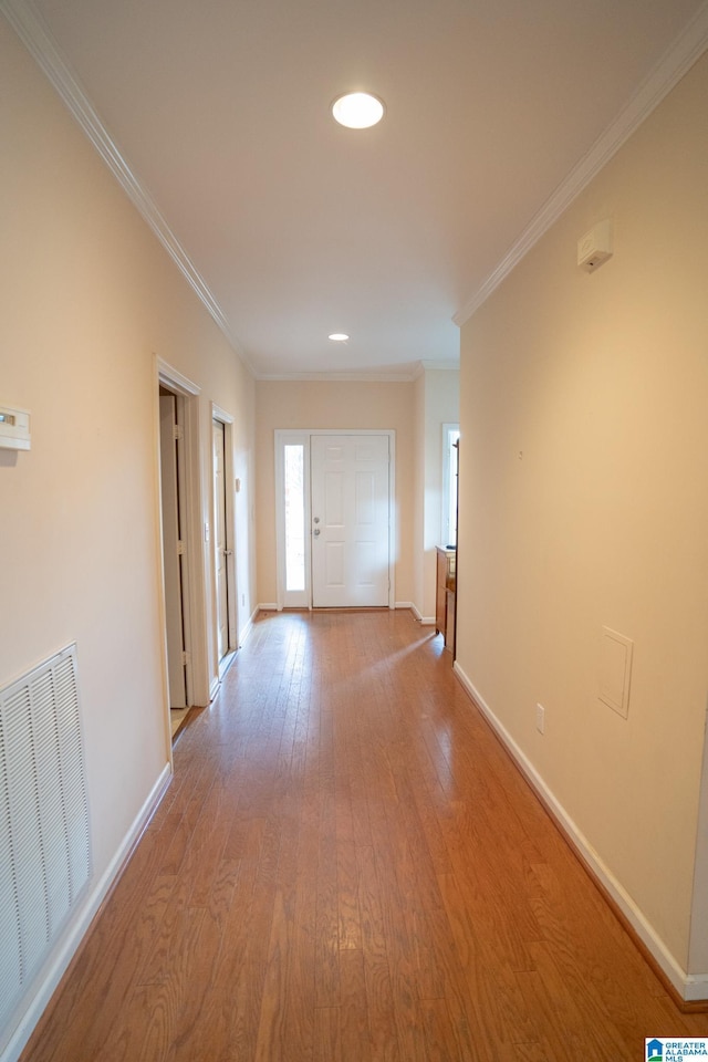 corridor featuring light wood-type flooring and crown molding