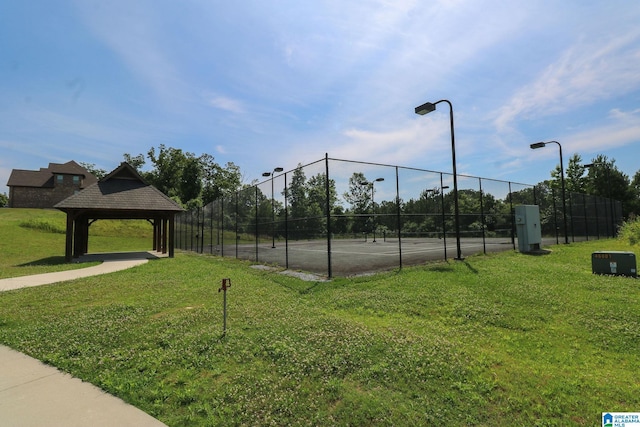 view of tennis court featuring a gazebo and a lawn