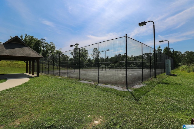 view of tennis court with a lawn