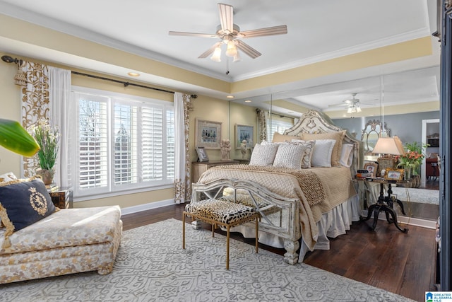 bedroom featuring hardwood / wood-style floors, a raised ceiling, ceiling fan, and ornamental molding