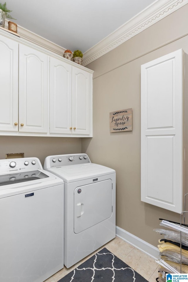 clothes washing area with washer and clothes dryer, cabinets, light tile patterned floors, and ornamental molding