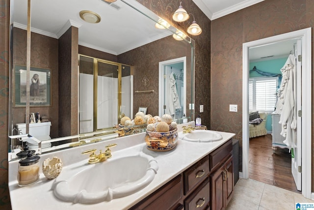 bathroom featuring vanity, tile patterned floors, toilet, ornamental molding, and an enclosed shower