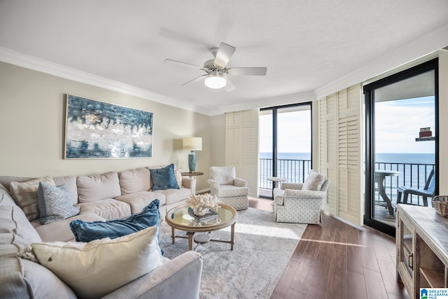 living room with a water view, hardwood / wood-style flooring, crown molding, and ceiling fan