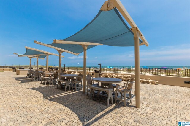 view of patio / terrace with a water view and a beach view