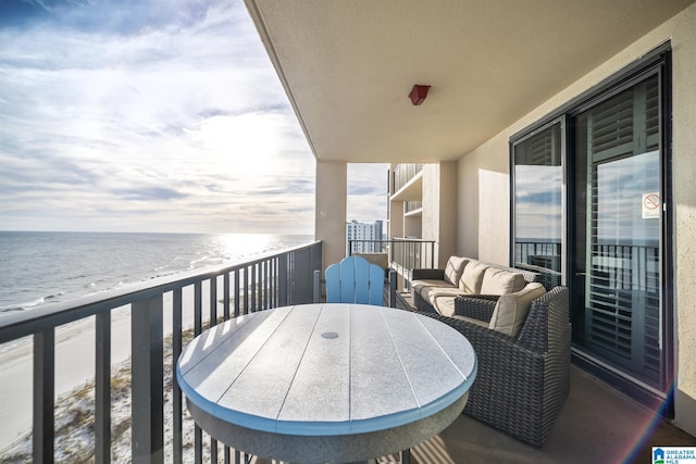 balcony featuring outdoor lounge area, a water view, and a beach view