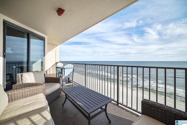 balcony featuring a view of the beach, outdoor lounge area, and a water view