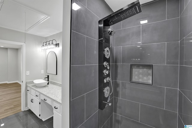 bathroom with a tile shower, vanity, and tile patterned floors