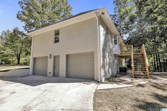 view of home's exterior with a garage and central AC unit