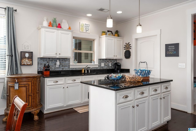 kitchen featuring tasteful backsplash, a center island, sink, and white cabinets