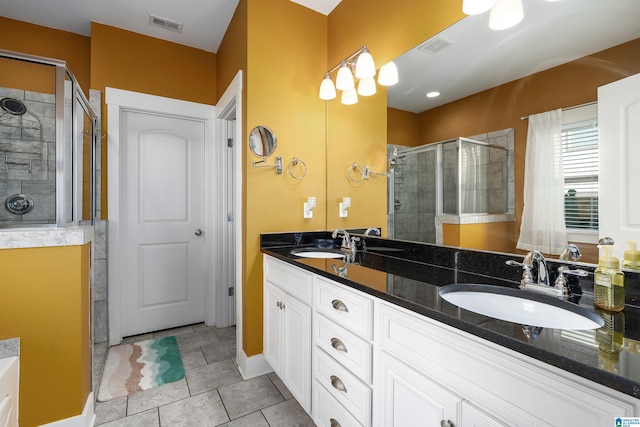 bathroom with tile patterned flooring, vanity, and walk in shower