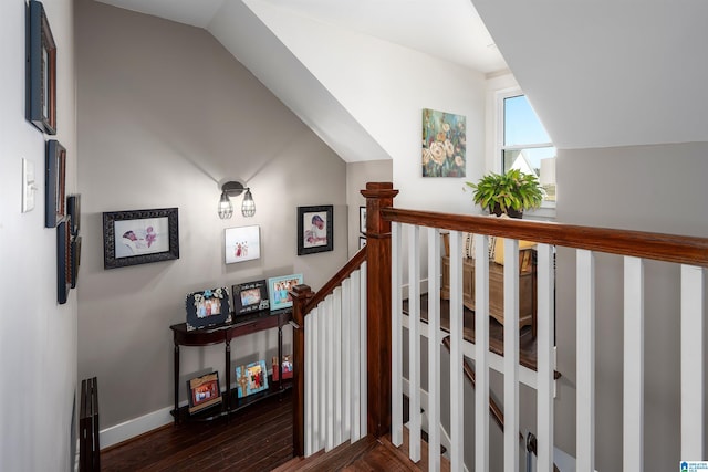 stairway featuring lofted ceiling and wood-type flooring