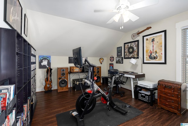 exercise room with vaulted ceiling, dark wood-type flooring, and ceiling fan