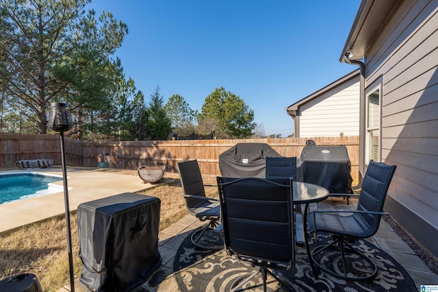 view of patio / terrace with a fenced in pool and a grill