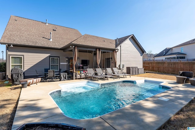 back of property with cooling unit, a fenced in pool, and a patio