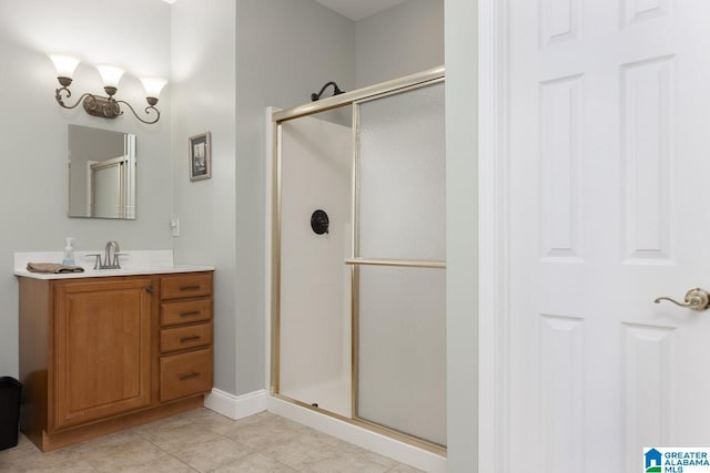 bathroom with tile patterned flooring, a shower with shower door, and vanity