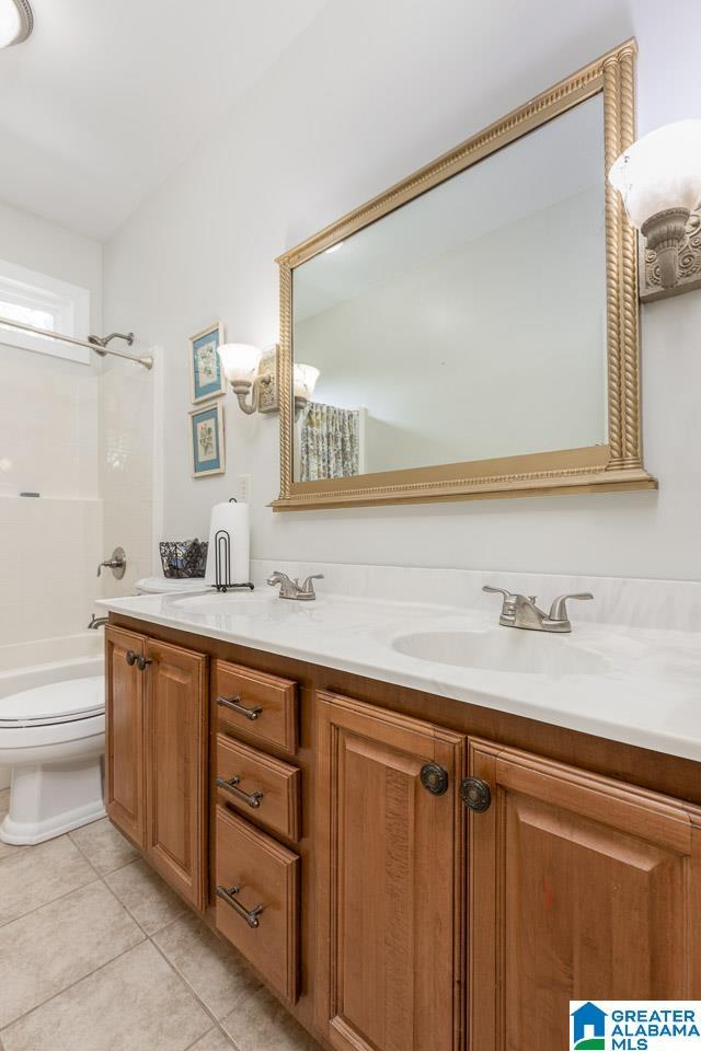 full bathroom with toilet, vanity, tile patterned flooring, and bathtub / shower combination