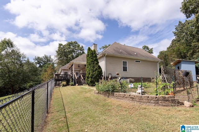 view of side of home featuring a deck and a lawn