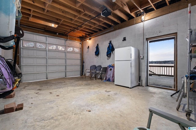 garage with a garage door opener and white refrigerator