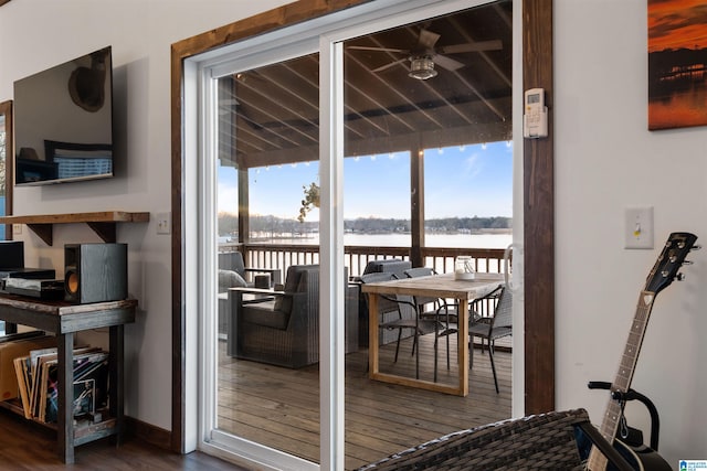 doorway to outside featuring ceiling fan, dark wood-type flooring, and a water view