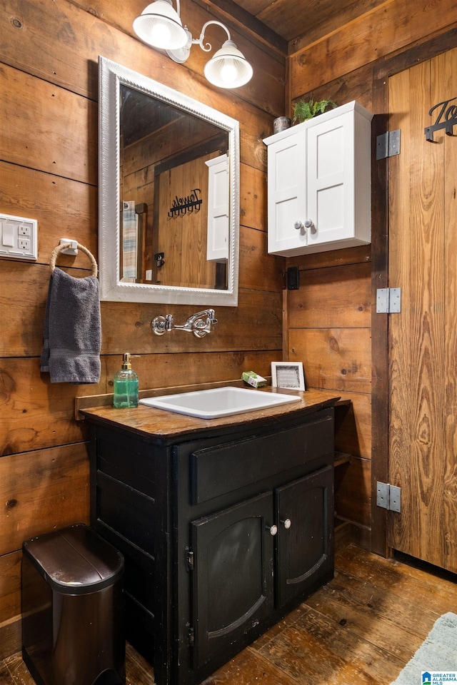 bathroom featuring wood-type flooring, vanity, and wood walls