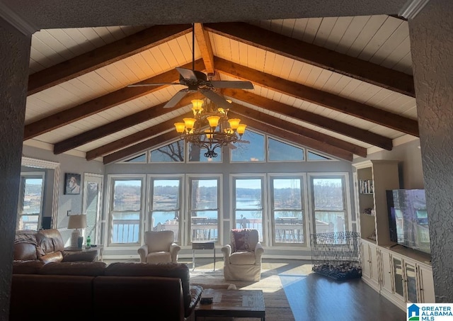 living room with a notable chandelier, beam ceiling, a healthy amount of sunlight, and hardwood / wood-style flooring