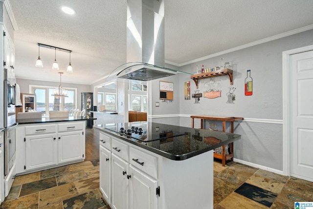 kitchen with a kitchen island, island range hood, white cabinetry, a kitchen breakfast bar, and a textured ceiling