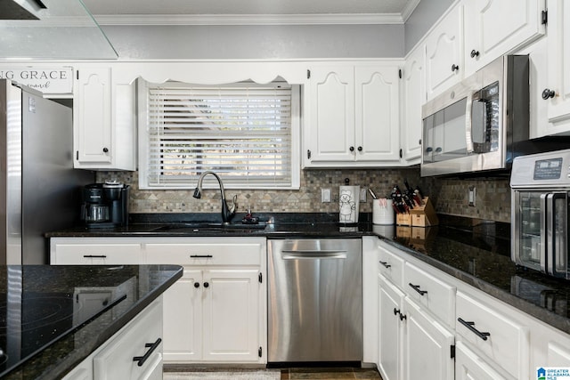 kitchen featuring dark stone countertops, stainless steel appliances, and white cabinets