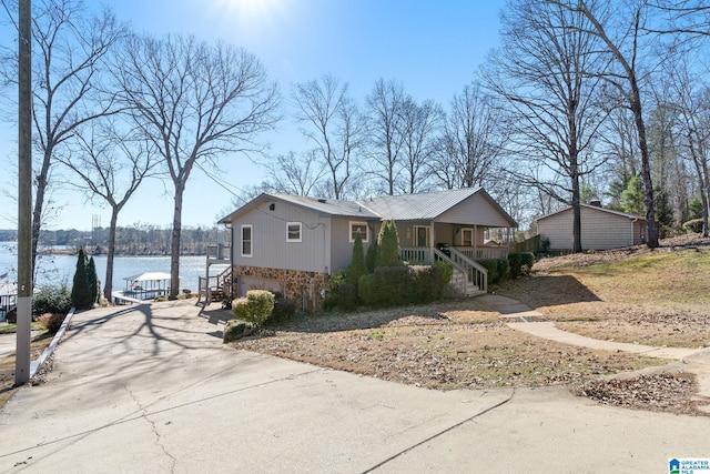 view of side of property featuring a porch and a water view