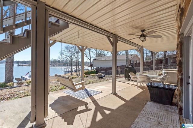 view of patio featuring a water view and ceiling fan