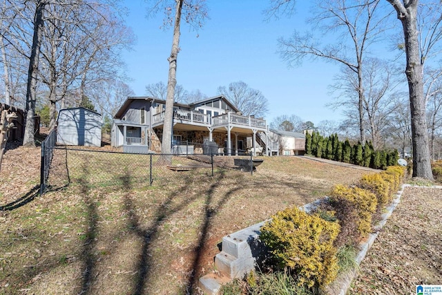 back of property featuring a wooden deck and a lawn