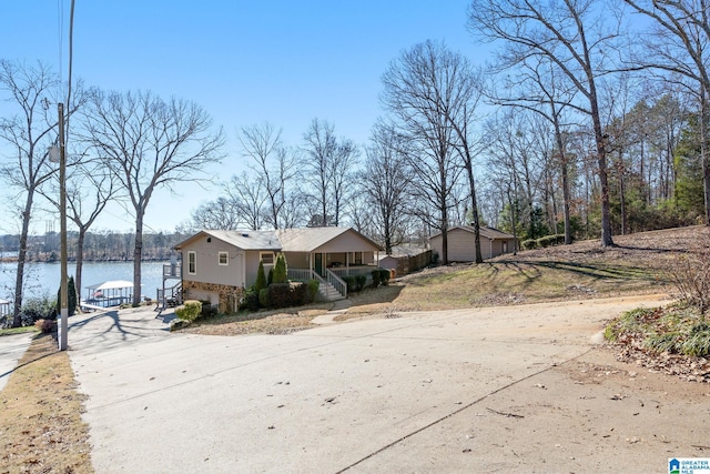 view of front of property with a garage, a porch, and a water view