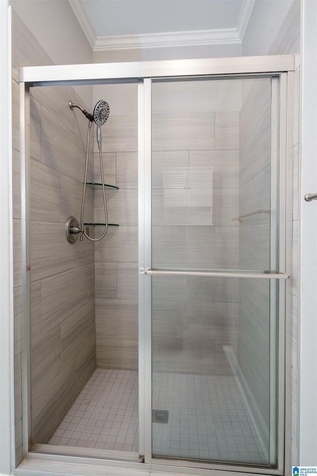 bathroom with a shower with door and ornamental molding