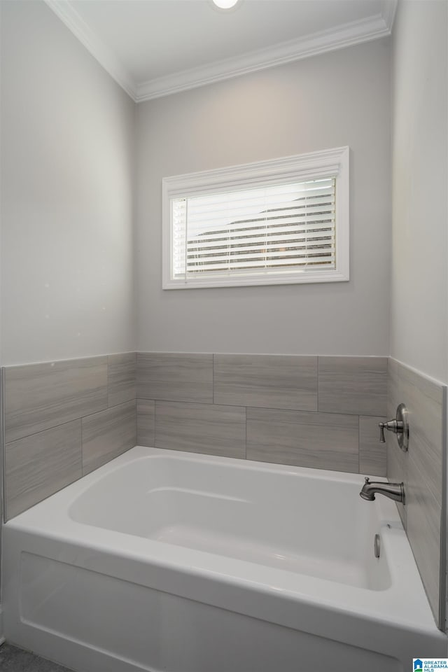 bathroom featuring crown molding and a tub