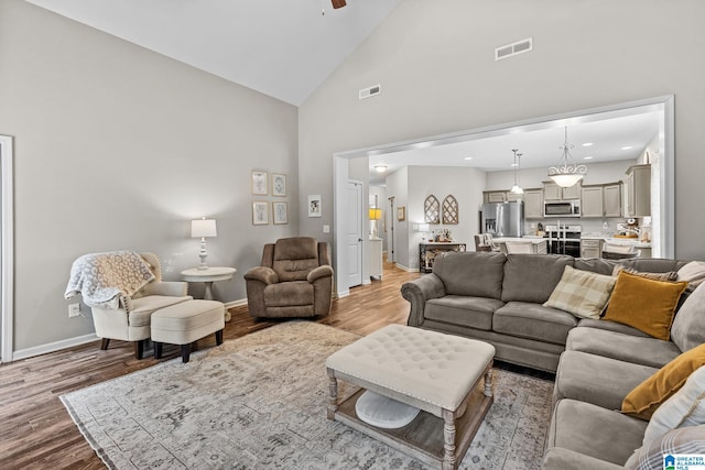 living room with high vaulted ceiling, wood-type flooring, and ceiling fan