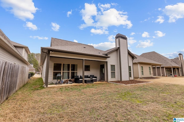 rear view of property featuring a yard, an outdoor hangout area, and a patio