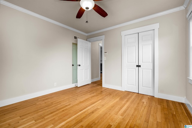 unfurnished bedroom with ceiling fan, light wood-type flooring, ornamental molding, and a closet