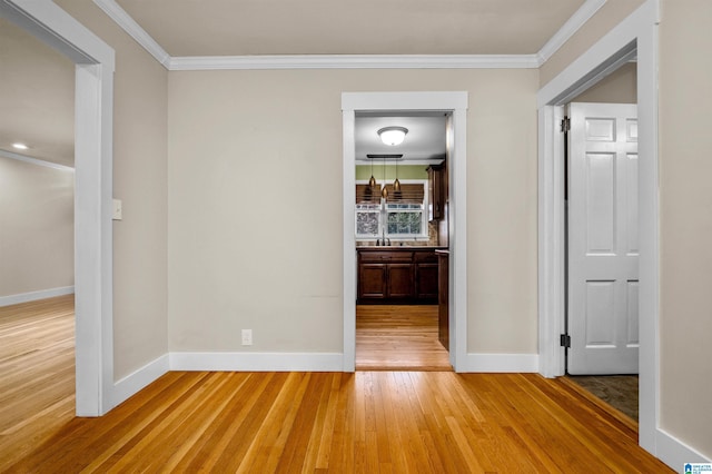 hallway with wood-type flooring and ornamental molding