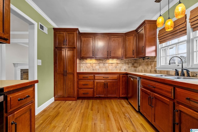 kitchen featuring pendant lighting, sink, light hardwood / wood-style flooring, stainless steel dishwasher, and backsplash