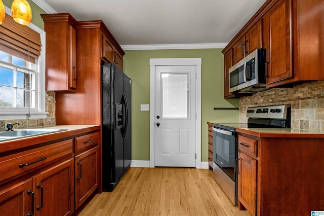 kitchen with decorative backsplash, light hardwood / wood-style floors, crown molding, and appliances with stainless steel finishes