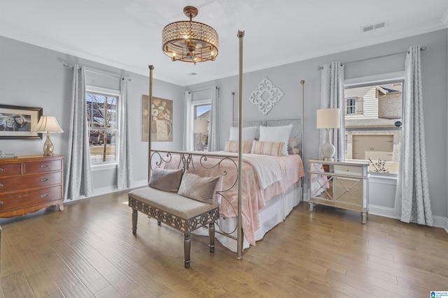 bedroom with wood-type flooring and crown molding