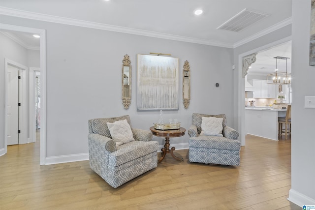 sitting room featuring ornamental molding and light hardwood / wood-style flooring