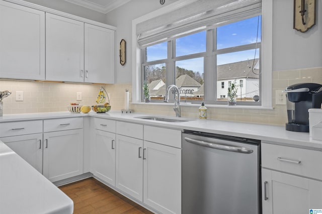 kitchen featuring sink, white cabinets, dishwasher, tasteful backsplash, and wood-type flooring