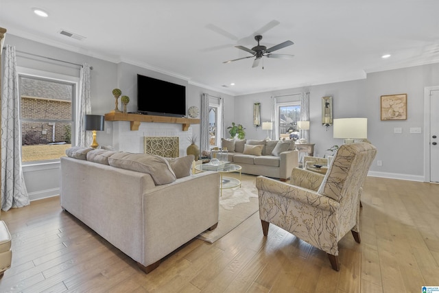 living room with ceiling fan, ornamental molding, and light hardwood / wood-style flooring