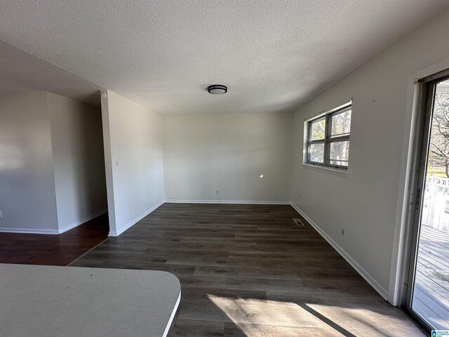 empty room featuring dark wood-type flooring and a textured ceiling