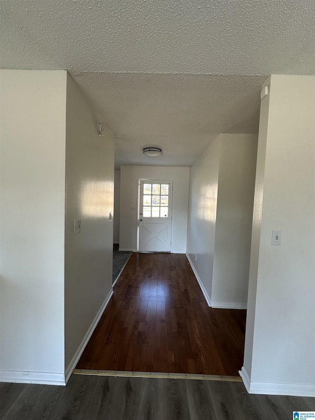 hallway featuring dark hardwood / wood-style flooring and a textured ceiling