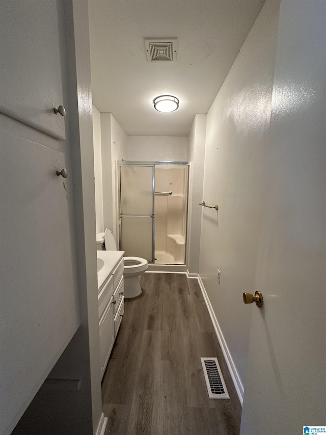 bathroom featuring vanity, toilet, hardwood / wood-style floors, and an enclosed shower