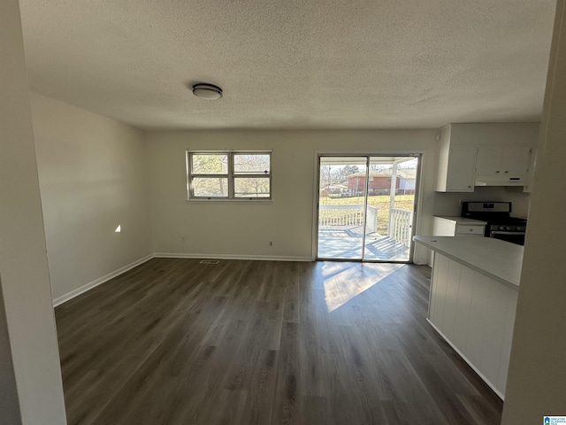 unfurnished living room featuring a textured ceiling and dark wood-type flooring